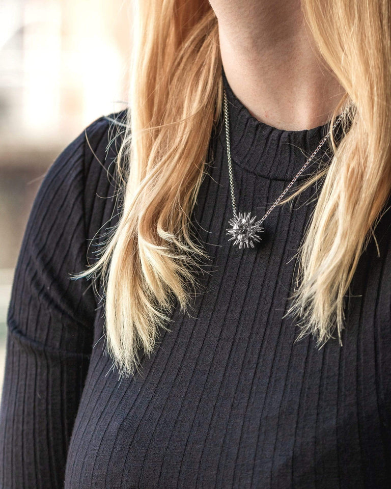 Pollen grain necklace displayed on a black background, emphasizing its elegant details. Pollen grain necklace displayed on a black background, emphasizing its elegant details.