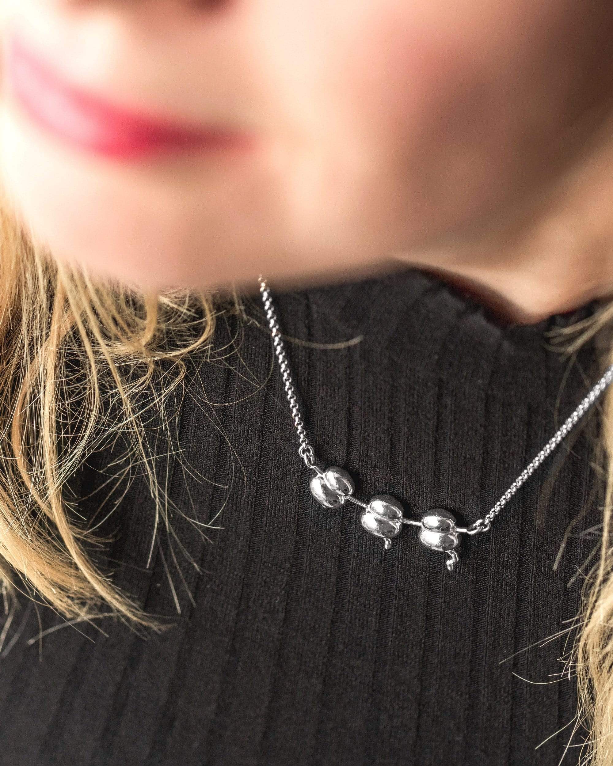 Close-up of Ribosomes Necklace worn around the neck, highlighting the silver pendant’s scientific inspiration and detailed craftsmanship. Close-up of Ribosomes Necklace worn around the neck, highlighting the silver pendant’s scientific inspiration and detailed craftsmanship.