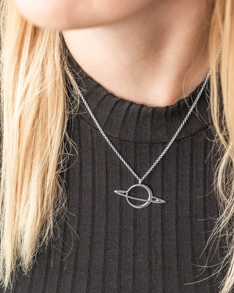 Model wearing the Silver Saturn Necklace, capturing cosmic elegance with a planetary design inspired by Saturn. Model wearing the Silver Saturn Necklace, capturing cosmic elegance with a planetary design inspired by Saturn.