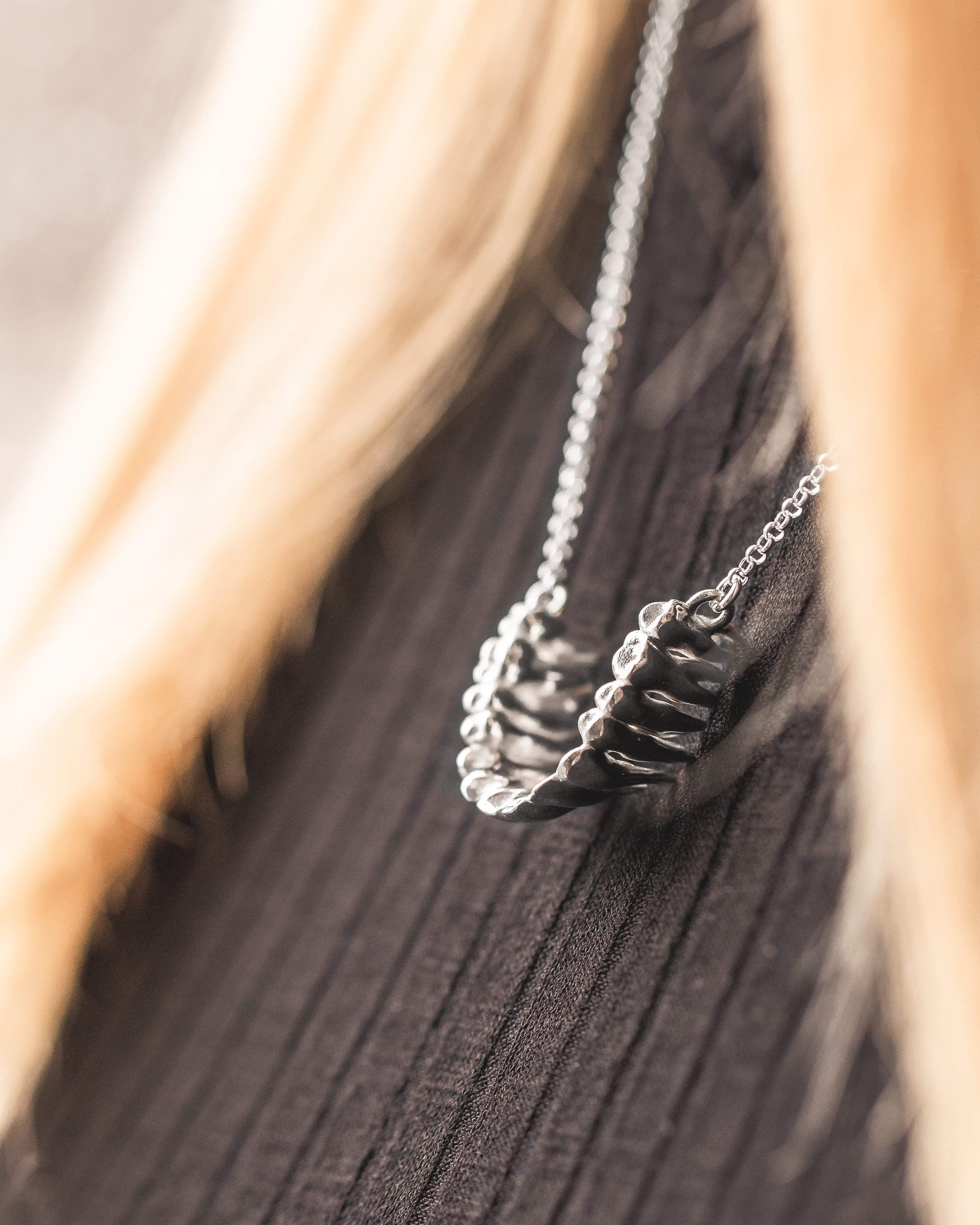 Close-up of a teeth necklace worn over a black top – stylish and quirky science jewelry. Close-up of a teeth necklace worn over a black top – stylish and quirky science jewelry.