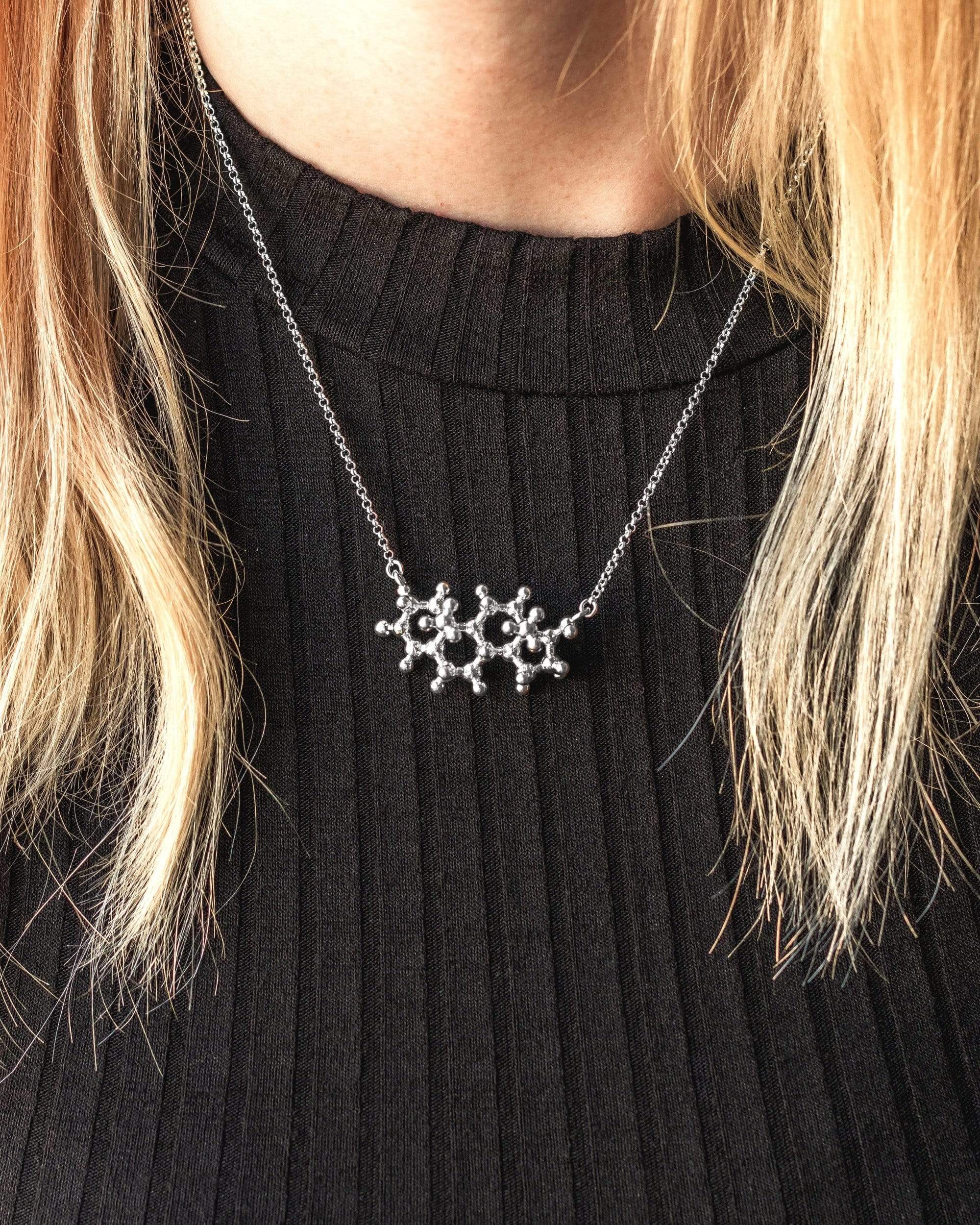 Model wearing a testosterone necklace, showcasing its intricate molecular design and stylish look. Model wearing a testosterone necklace, showcasing its intricate molecular design and stylish look.