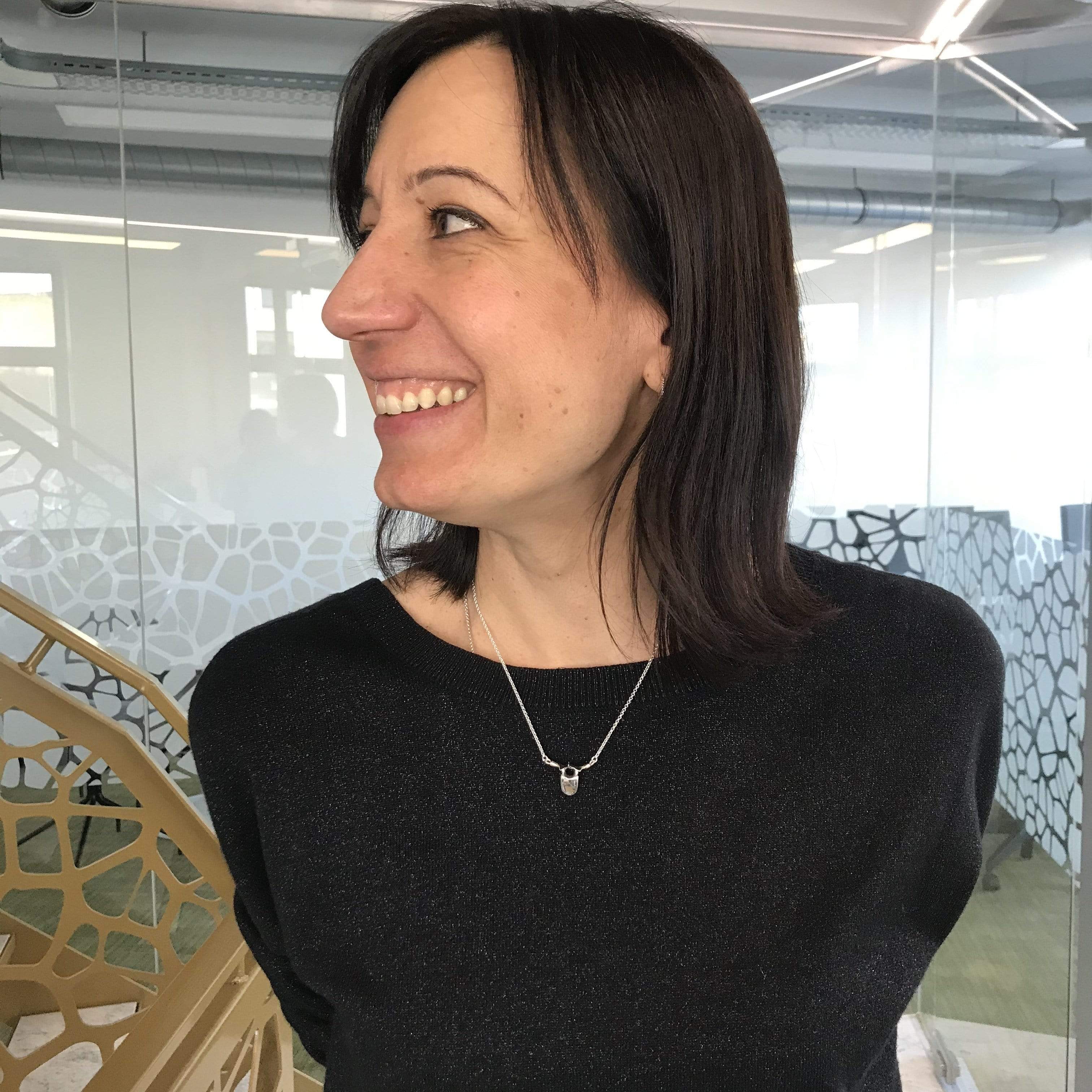 A woman wearing the thoracic vertebra necklace, highlighting its elegant and anatomical design. A woman wearing the thoracic vertebra necklace, highlighting its elegant and anatomical design.