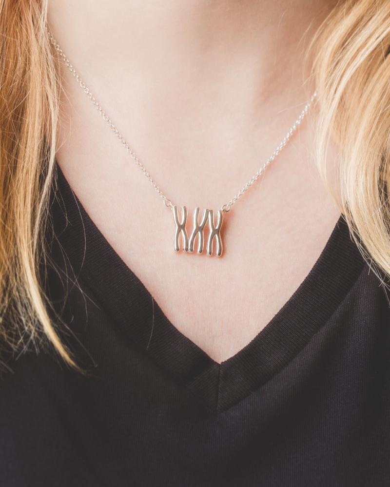 Close-up of trisomy 21 Down Syndrome necklace on a model, showing its sleek and elegant design. Close-up of trisomy 21 Down Syndrome necklace on a model, showing its sleek and elegant design.
