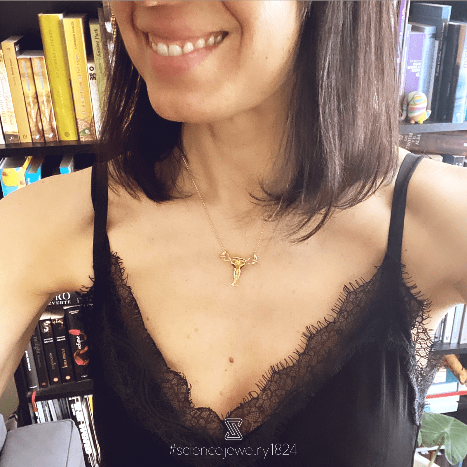 Close-up of a model wearing the gold vermeil uterus necklace, highlighting its intricate details. Close-up of a model wearing the gold vermeil uterus necklace, highlighting its intricate details.