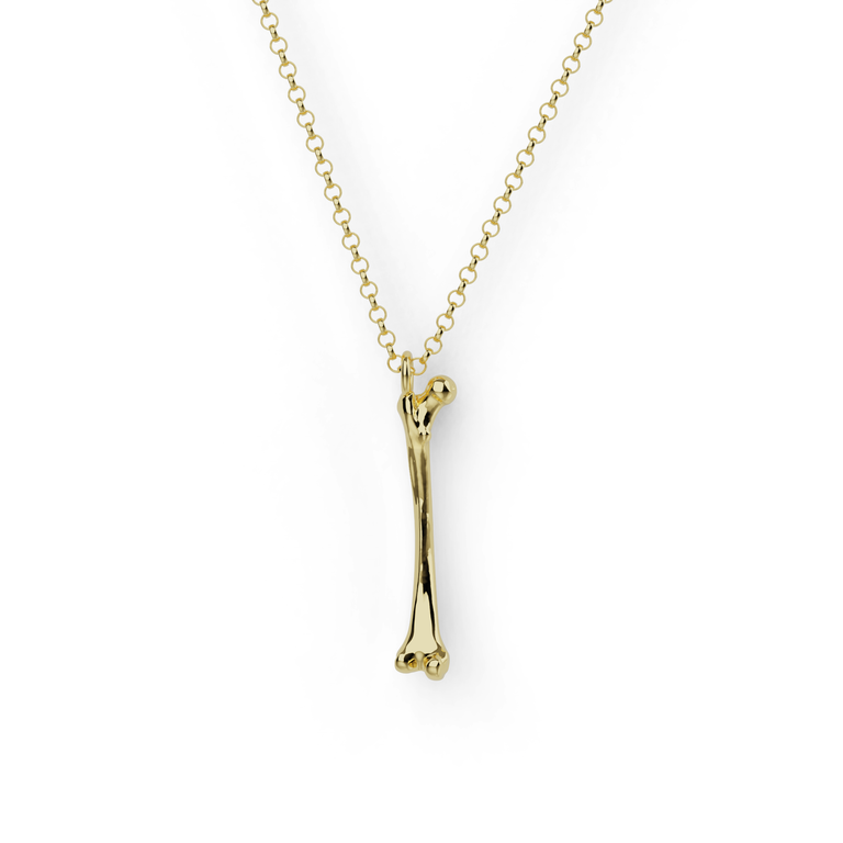Close-up of gold vermeil femur necklace pendant with realistic anatomical detail – femur necklace for science lovers
