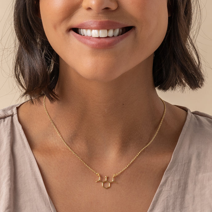 Model wearing gold propofol molecule necklace – elegant science jewelry gift for medical professionals and chemistry lovers.