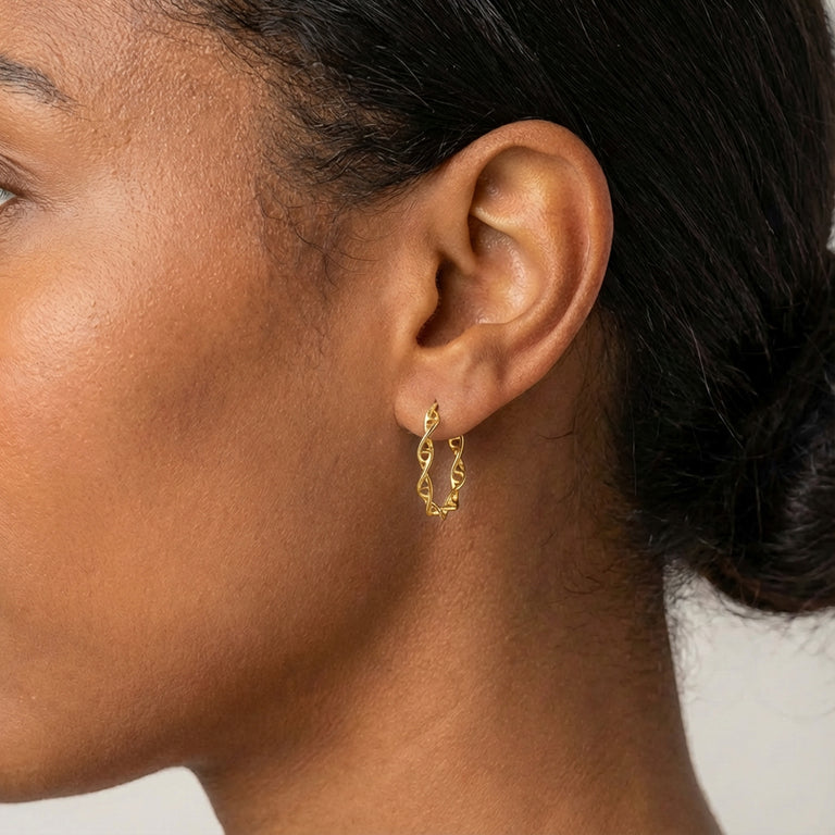 Side profile of a woman wearing a small gold vermeil DNA hoop earring, showing size and fit on the earlobe.