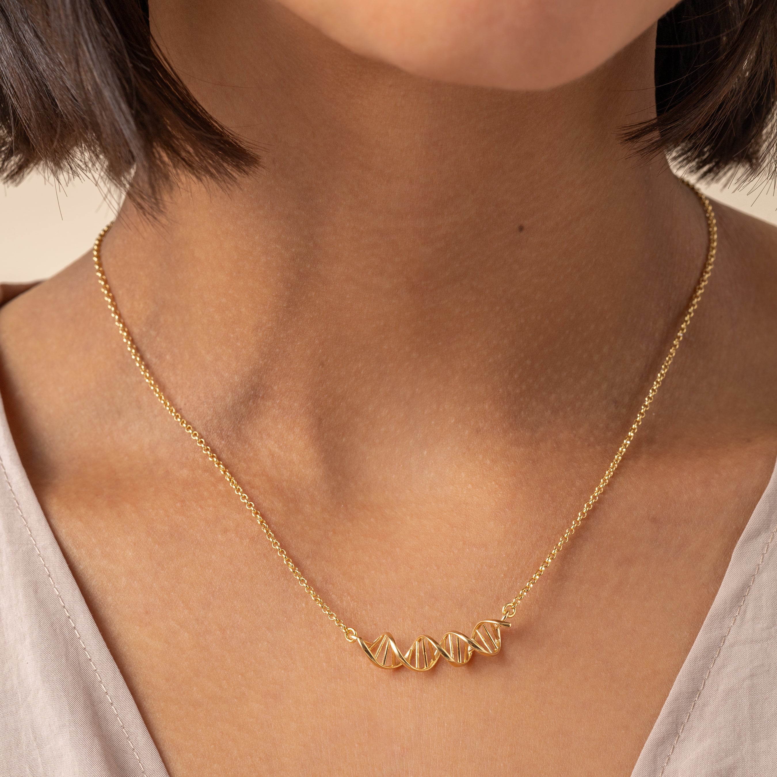 Model wearing an 18K gold vermeil DNA necklace, perfect for science lovers