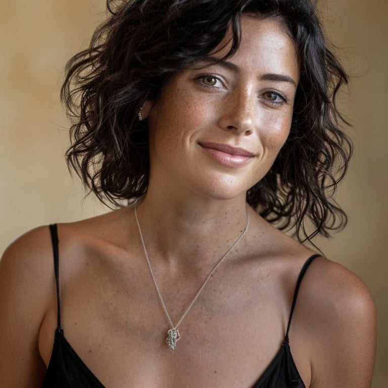 Smiling woman wearing the Human Growth Hormone molecule pendant in sterling silver – minimalist science necklace representing growth and vitality.