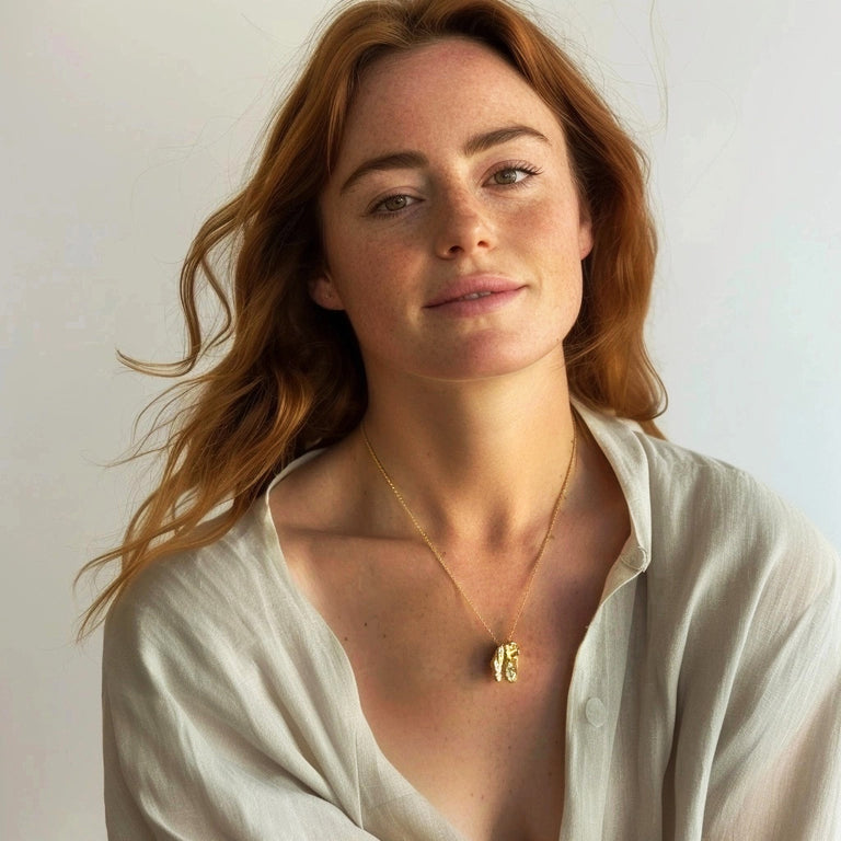 Red-haired woman wearing a gold T-Rex skull necklace, casually styled with a light blouse, showing the piece’s bold yet elegant look.