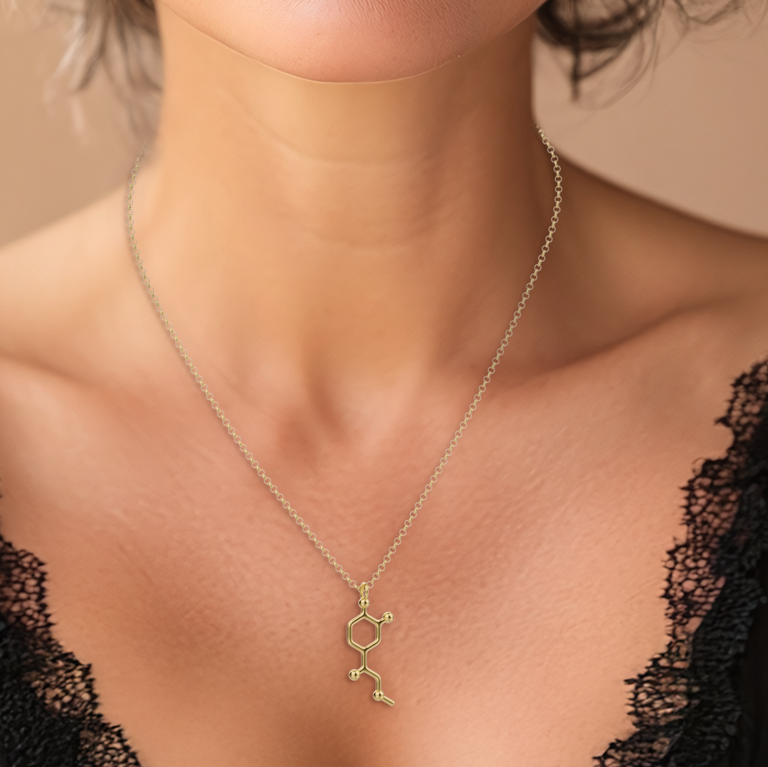 Close-up view of a woman wearing the adrenaline necklace in gold vermeil, highlighting the detailed molecular structure design.