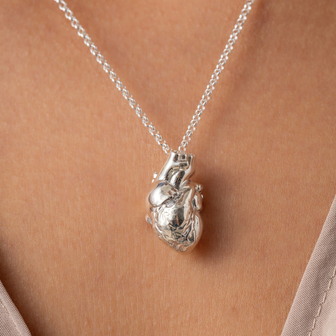 Anatomical Heart Necklace worn by a model, showcasing the detailed design and silver finish.