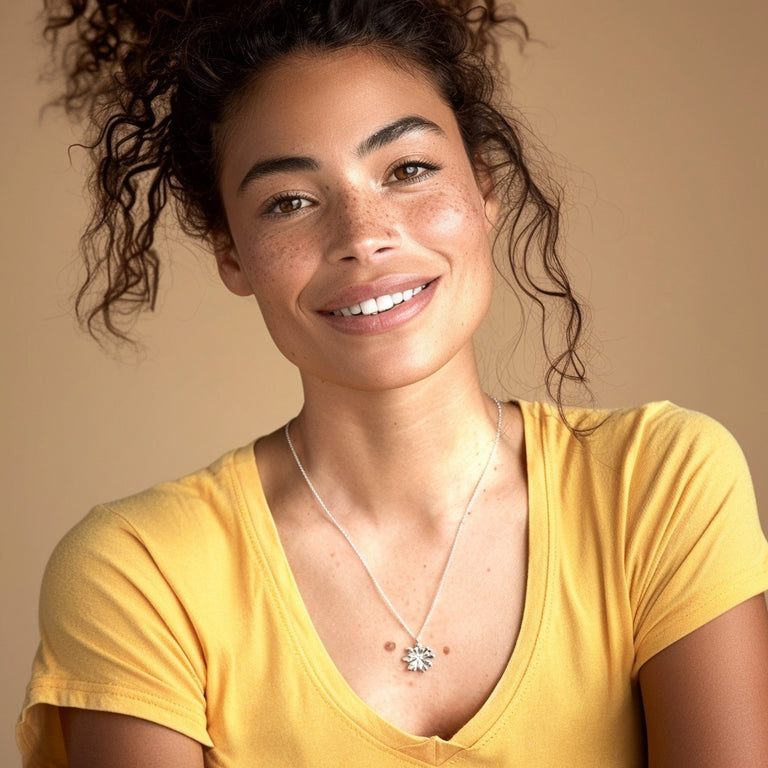 Smiling woman wearing a yellow shirt and the Arabidopsis Necklace, showcasing the jewelry’s elegant plant-inspired design.