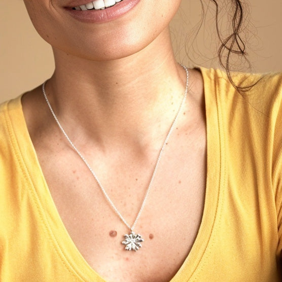 Woman wearing the Arabidopsis Necklace in sterling silver, showing the pendant resting at the center of her chest.