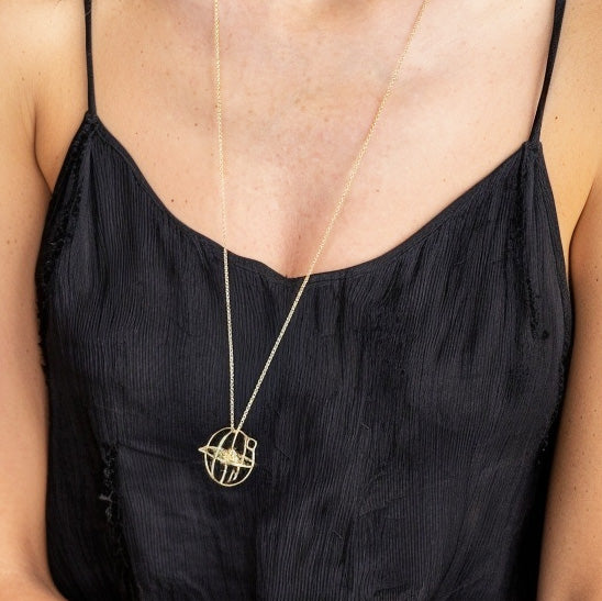 Gold vermeil atom pendant necklace displayed on a woman’s chest, illustrating the elegant scientific design and pendant size.