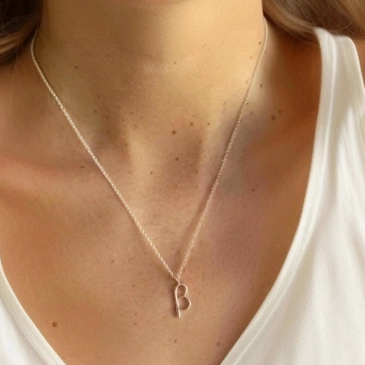 Close-up view of a woman wearing the beta necklace, highlighting the pendant against a white tank top.