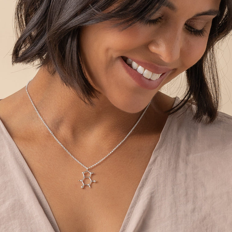 Caffeine molecule necklace on a model, demonstrating its versatility and how it adds a scientific touch to everyday wear.