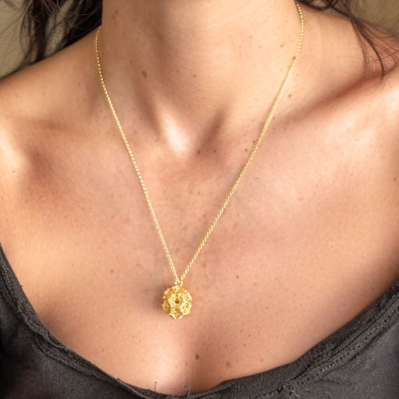 Close-up of the Gold Vermeil Clathrin Necklace resting on a woman’s collarbone, highlighting the intricate molecular mesh design.