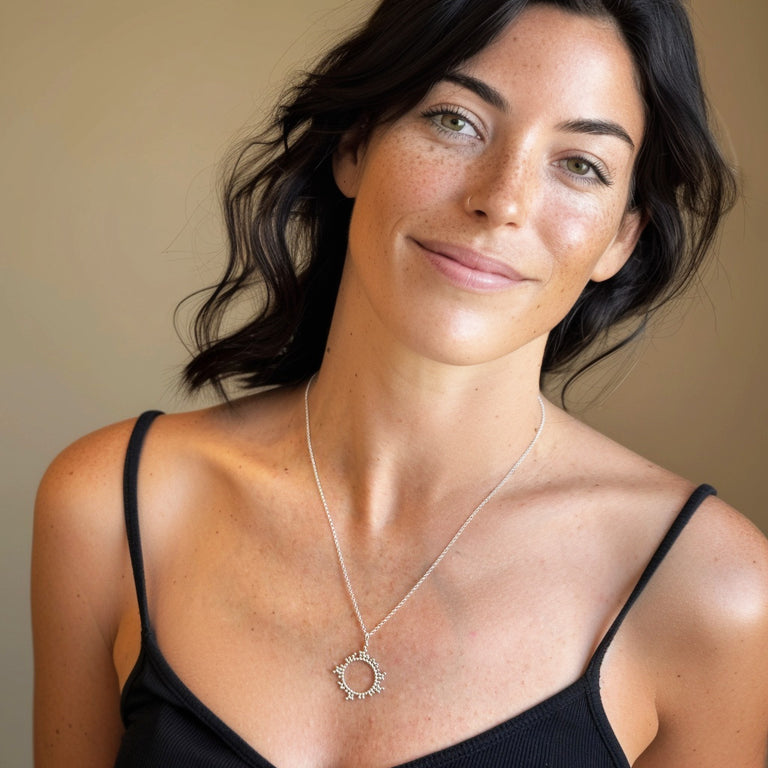Smiling woman wearing cyclo­sporine molecule necklace — science-inspired jewelry symbolizing peacekeeping of the immune system, combining molecular biology with minimalist fashion design.