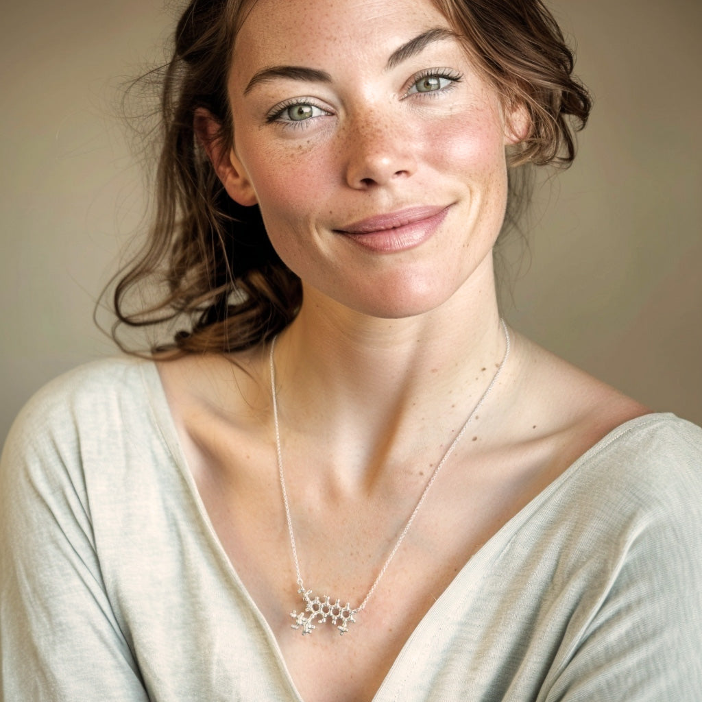 Smiling woman wearing a sterling silver doxorubicin molecule necklace, shown against a neutral background.