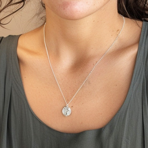 Close-up of the eosinophil necklace pendant resting on a woman’s collarbone, highlighting the detailed design and delicate chain.
