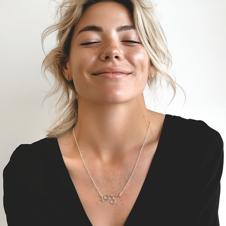 Woman wearing fluoxetine molecule necklace in sterling silver – science jewelry symbolizing serotonin, resilience, and mental wellness.