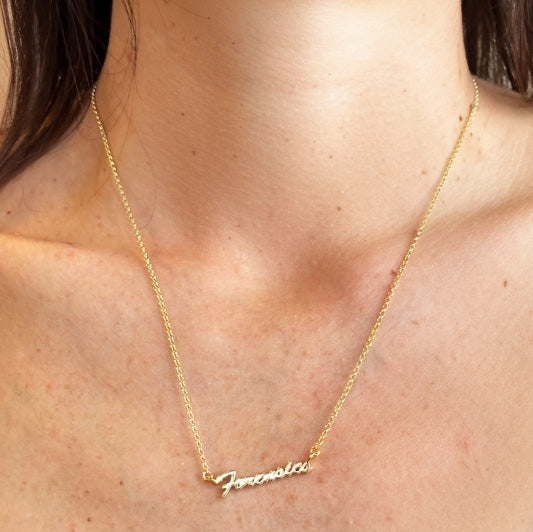 Forensics necklace in gold vermeil worn as minimalist science jewelry, close-up view on neckline