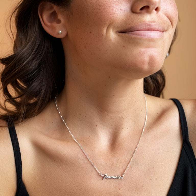 Model smiling while wearing silver Forensics Necklace, geek-chic jewelry for crime scene science and true crime fans.
