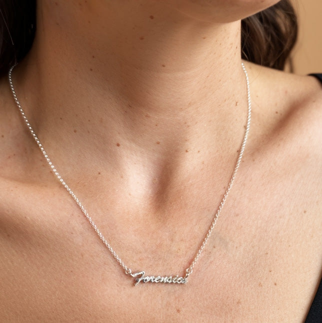 Woman wearing Forensics Necklace in sterling silver, elegant science jewelry celebrating forensic science and criminology.