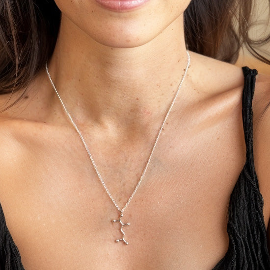 Close-up of Glutamate molecule pendant on silver chain — elegant geek chic jewelry for students, neurologists, and science enthusiasts.