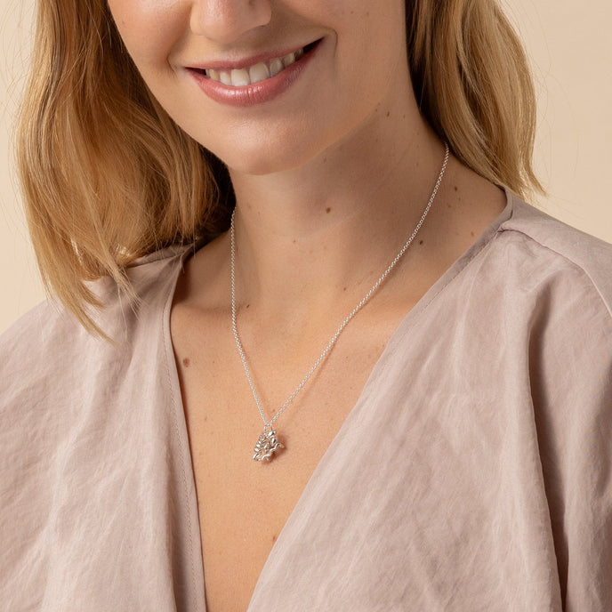 Model wearing insulin necklace, highlighting science-inspired diabetes jewelry.