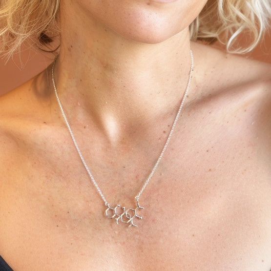 Close-up view of the Ketamine Propofol Necklace worn around the neck, showing its elegant interlocked molecular design.