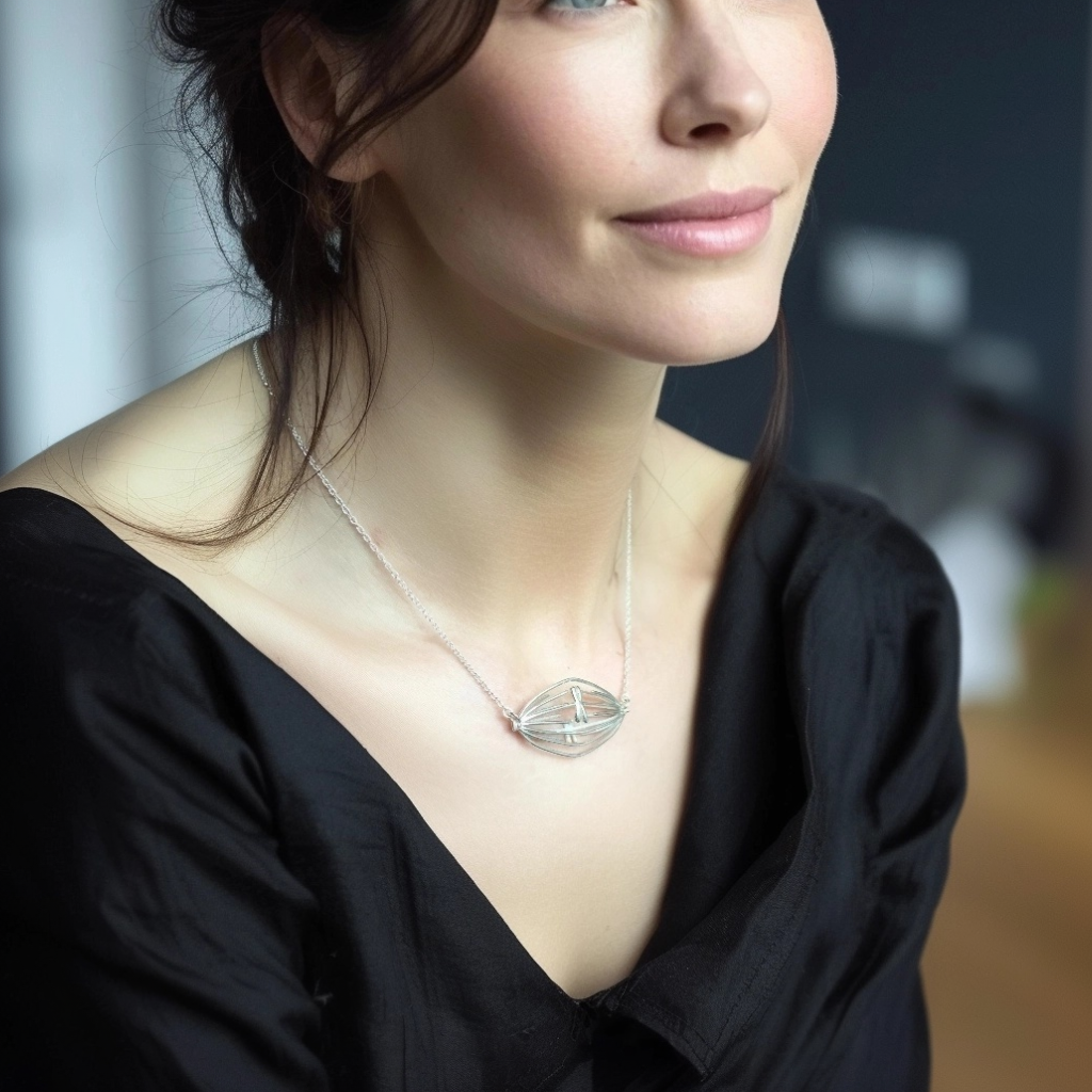 Sterling silver mitosis necklace worn by a woman in a black top, highlighting the elegant biological structure.