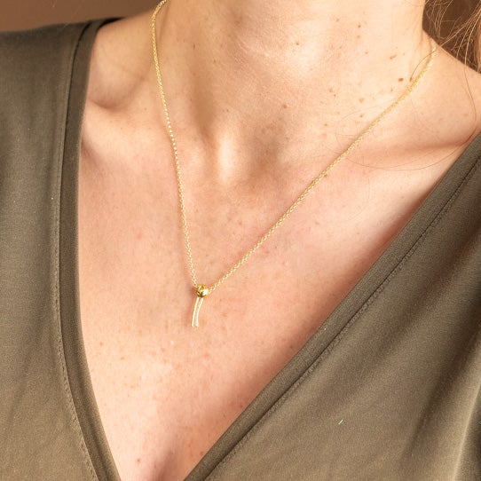 Phospholipid Necklace in gold vermeil worn on a model’s neck, highlighting the elegant, minimalist cellular-inspired design.
