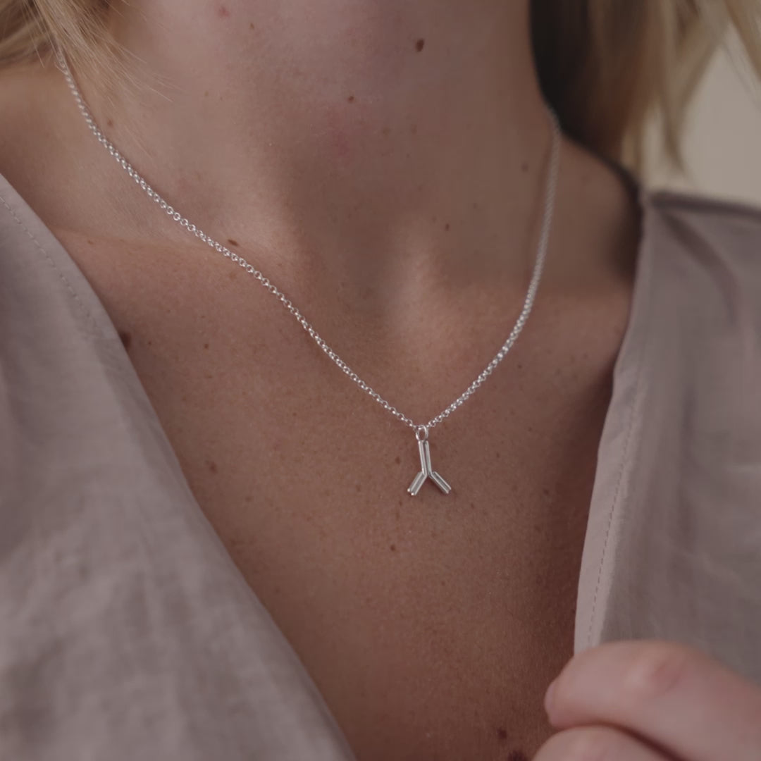 Close-up of antibody necklace in sterling silver, showcasing intricate science-inspired design in motion. Perfect for biology enthusiasts and healthcare professionals.