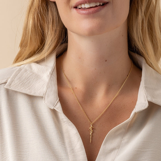 Close-up of the Rod of Asclepius gold vermeil necklace worn by a model, showcasing its elegant and symbolic design.