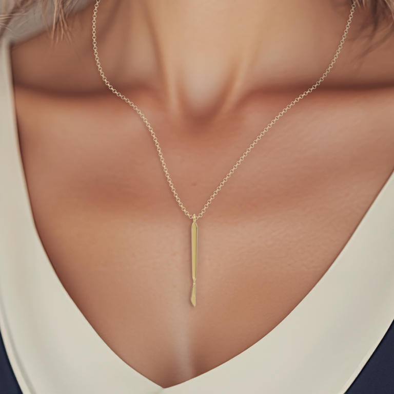 Close-up of a gold-plated scalpel pendant necklace on a model’s neck, showcasing elegance and scientific inspiration.