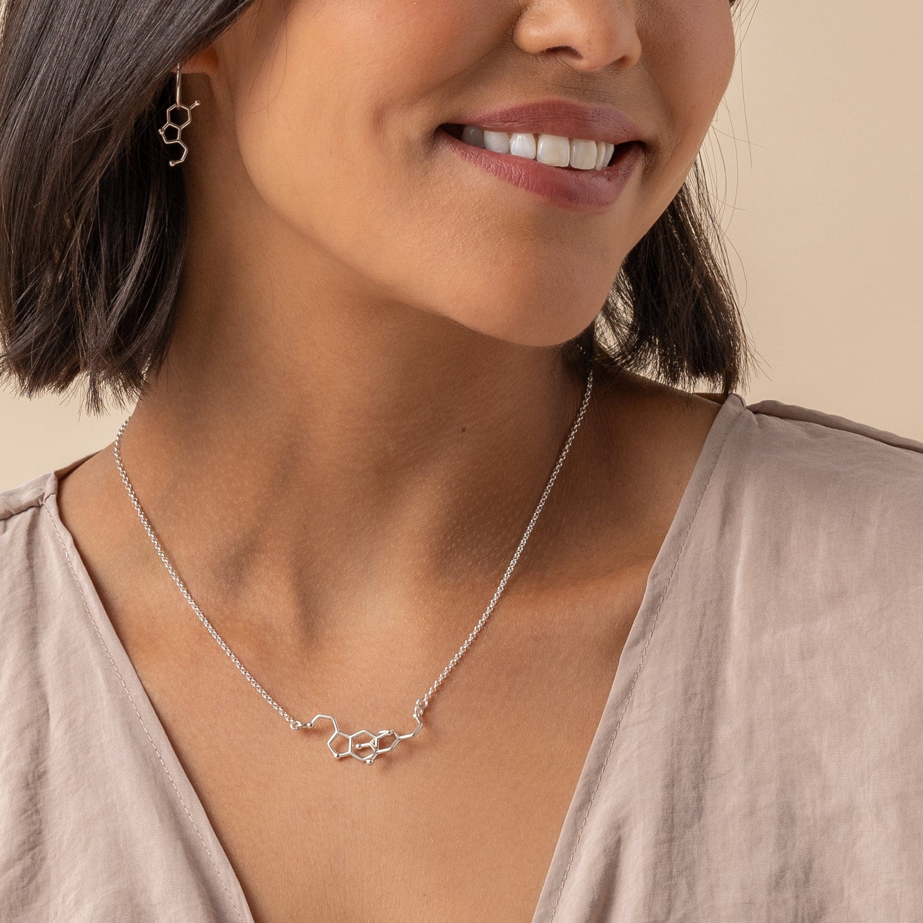 Model wearing Dopamine & Serotonin Necklace in silver, showcasing elegant and scientific style.