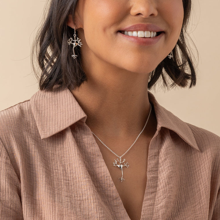 Close-up of a Silver Neuron Necklace worn by a model, showing its unique science-inspired charm.