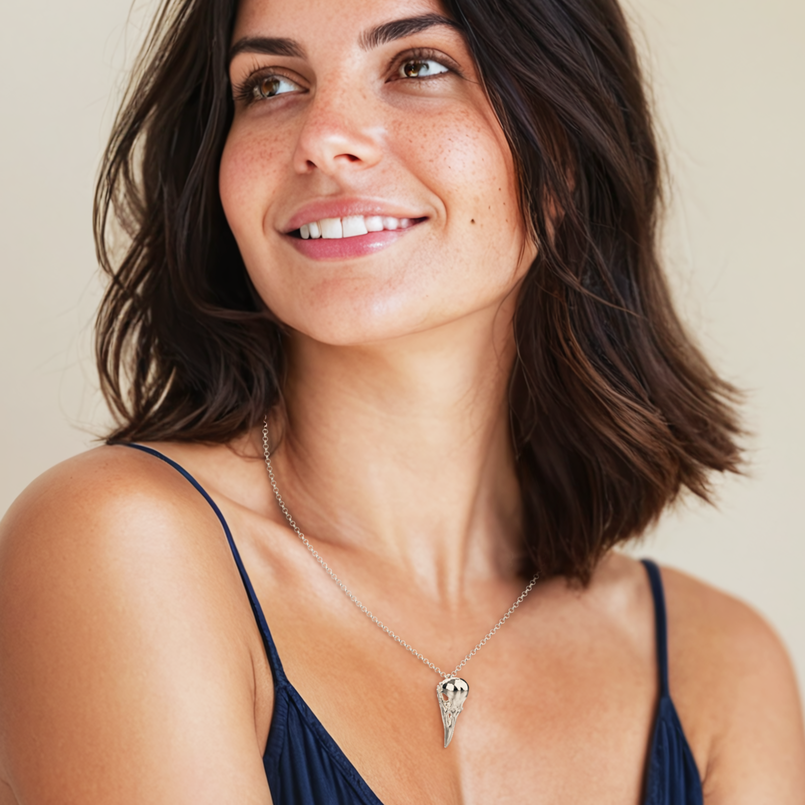 Woman wearing the Raven Skull Necklace, demonstrating the elegant yet bold look of the silver pendant.