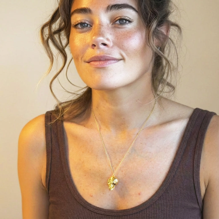 Woman wearing the gold vermeil skull necklace, showing scale, fit, and subtle anatomical detailing of the skull pendant.