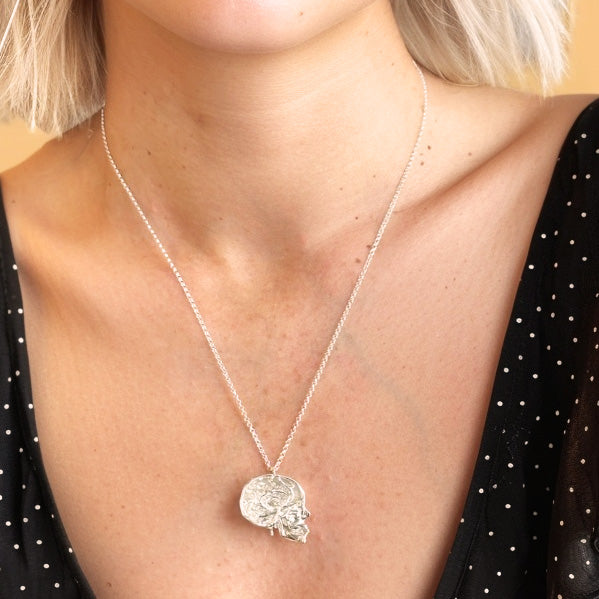 Model wearing the skull with vessels necklace in sterling silver – anatomical brain blood vessels design, science jewelry statement piece.