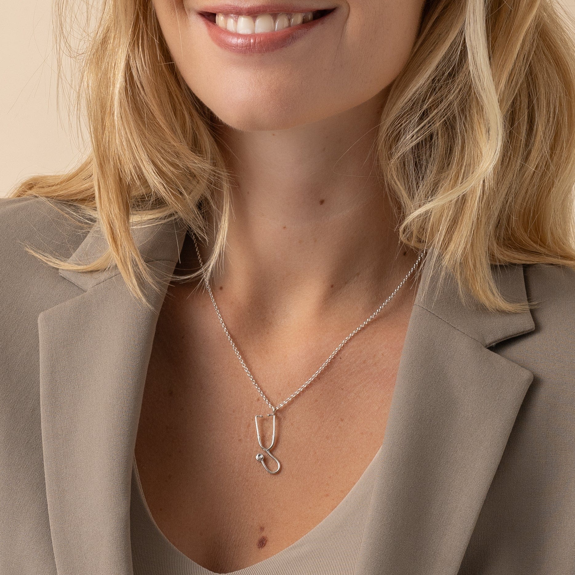 Close-up of the Stethoscope Necklace worn by a model, showcasing its sleek silver design.