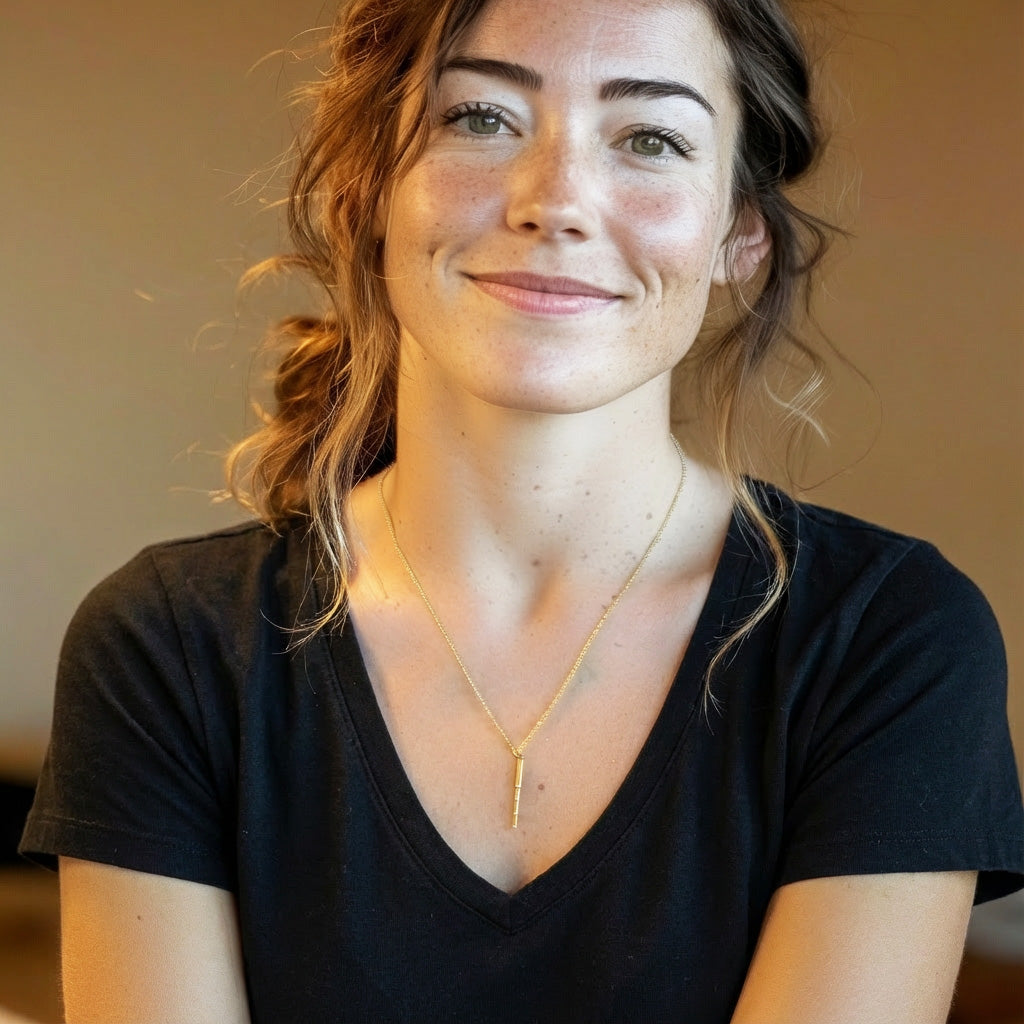 Woman wearing a gold vermeil telescope necklace, smiling and shown from the shoulders up for size and fit reference.