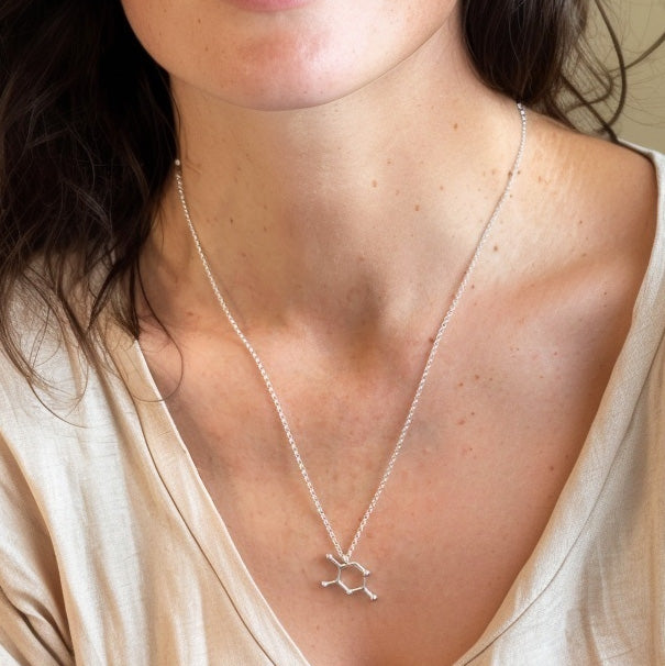 Model wearing the Thymine DNA necklace, highlighting the elegant and scientific design resting just below the collarbone.