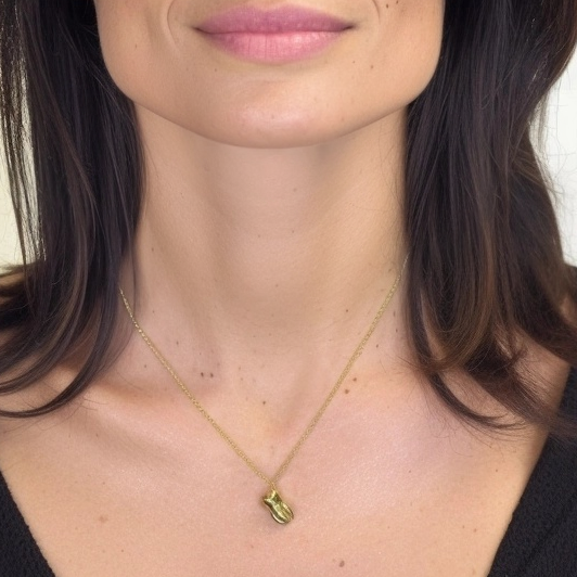 Model wearing the gold vermeil tooth necklace, shown close-up at the neck to highlight pendant size and chain length.