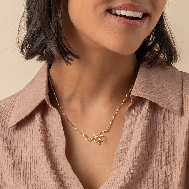 Model wearing the dopamine-serotonin necklace in gold vermeil, highlighting elegant and science-inspired jewelry design.