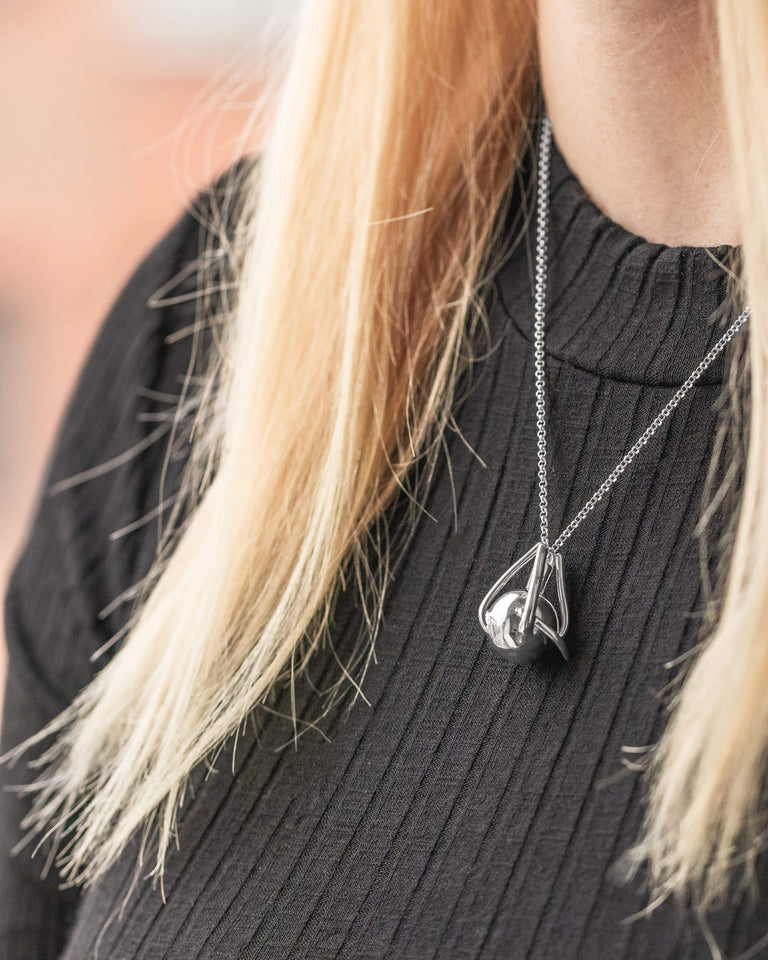 Close-up of the silver Eye Necklace, a perfect blend of science and fashion for enthusiasts.