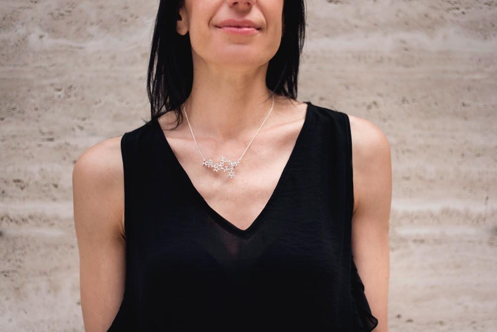 Model wearing the 3D printed oxytocin necklace in silver, highlighting the molecular design.