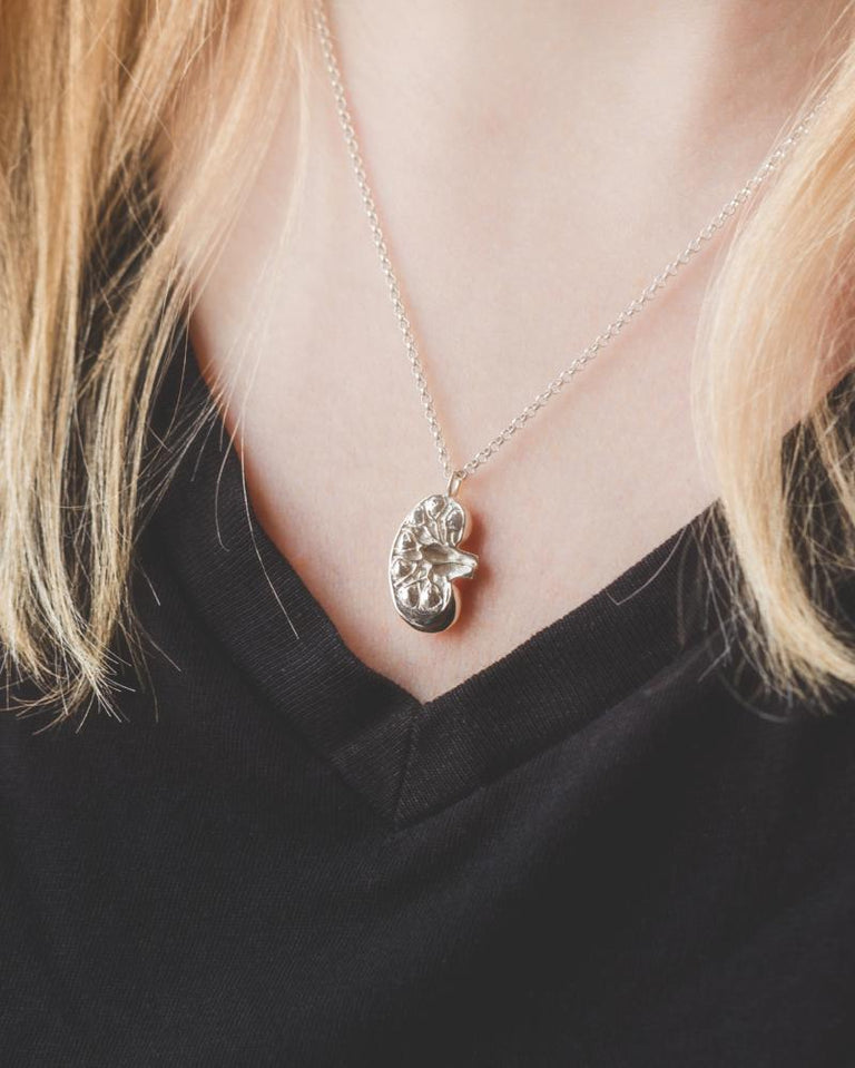 Close-up of the Sterling Silver Kidney Necklace on the model, highlighting its kidney-inspired design.